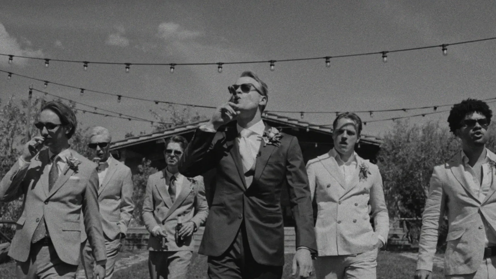 The groom and his groomsmen walking in, cigars in hand